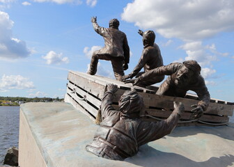 Monument depicting four men on a “board and barrel” raft on the waterfront in Sydney, Nova...