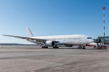 White wide body passenger jet plane at the gateway on the airport