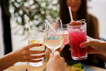 Friends toasting with cocktails and wine at a bistro