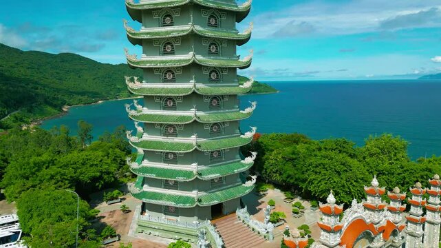 The Thap Xa Loi temple features intricate architecture, surrounded by lush greenery and a stunning ocean backdrop, symbolizing serenity and spirituality in Da Nang.