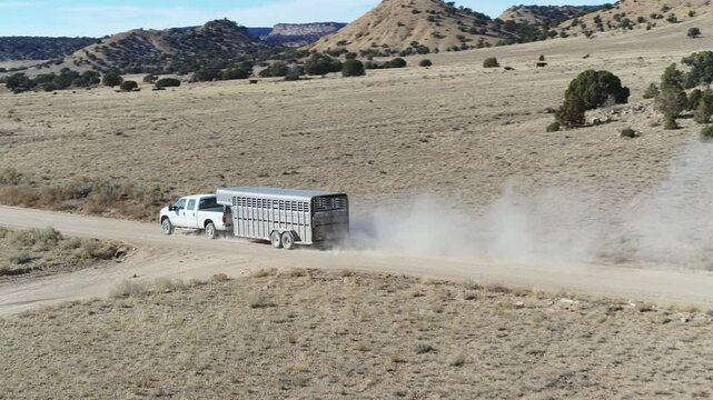 Aerial of truck pulling horse trailer in Central Utah desert on dirt road