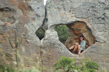 mulher em formações rochosas na trilha das umburanas, no vale do catimbau, pernambuco
