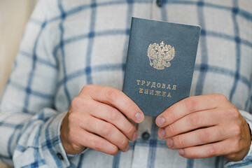 Man holds Work record book.  The inscription in Russian is a work book. Saint Petersburg, Russia - 28 Oct 2024