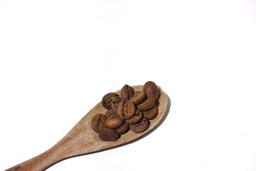 Coffee beans on wooden spoon isolated on white background. top view