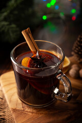 Spiced wine or Christmas mulled wine with orange, cinnamon, star anise, clove, nutmeg and other ingredients on a wooden rustic table. Traditional hot drink at winter time and Christmas holidays.