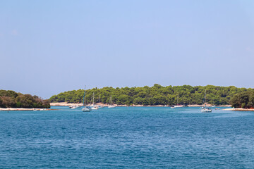 Sailing boats anchored around picturesque island Otocic Frasker and Fraskeric seen from Banjole,...