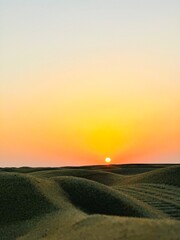 sunset over the field of the desert dunes