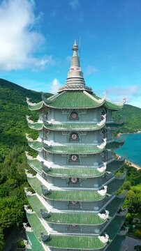 Thap Xa Loi is a stunning Buddhist temple in Da Nang, showcasing intricate architecture and vibrant green roofs against a backdrop of lush mountains and blue ocean.