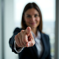 Right hand pointing forward gesture. Expressive shot of a woman in suit blurred in the background. Business concept