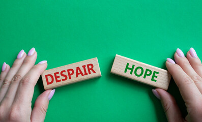 Despair or Hope symbol. Concept word Despair or Hope on wooden blocks. Businessman hand. Beautiful green background. Business and Despair or Hope concept. Copy space