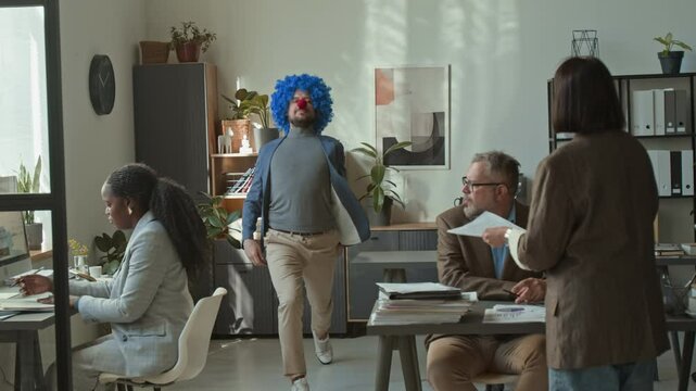 Excited businessman dancing, smiling, throwing papers, clown nose and wig in air, then leaving office after being fired, amazed colleagues watching him