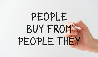 Fototapeta premium A hand is writing the word People Buy From People They on a white board