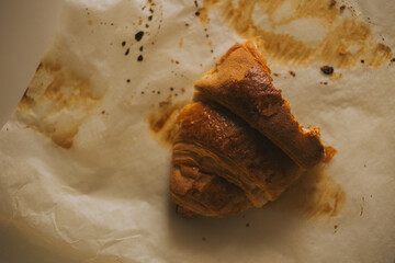 Top view of baking parchment with croissant marks. The grease stains and texture of the paper create an authentic look of the baking process. Perfect for visualizing cooking, home baking, and gastrono