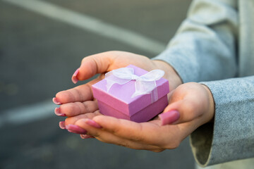 Woman holding a small pink gift box in her hands