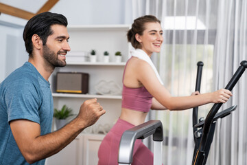 Fototapeta premium Athletic and sporty young couple or fitness buddy running on running machine together, home body workout exercise session as healthy sport lifestyle at home. Gaiety home exercise workout training.