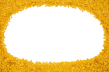 A white round hollow surface surrounded by yellow lentils.