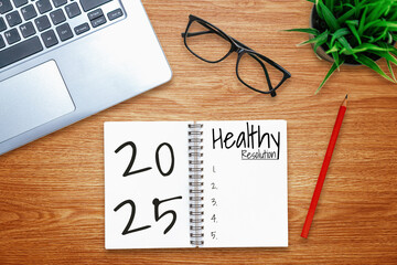 2025 Happy New Year Resolution Goal List and Plans Setting - Business office desk with notebook written about plan listing of new year goals and resolutions setting. Change and elation concept.
