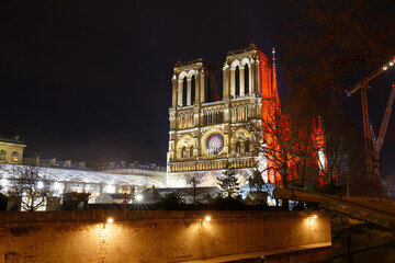 Naklejka premium Notre Dame Cathedral in Paris will reopen following a five-year restoration after the 2019 fire. The cathedral will feature a rebuilt spire, restored interiors, and preserved historical elements.