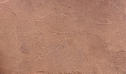 Wall plaster texture in a modern mocha mousse tone.Trending color of the year 2025 background.