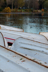 Rowboats resting on the shore of the peaceful lake in Bois de Vincennes, a serene environment in...