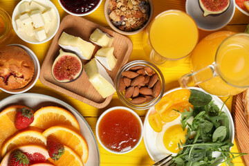 Different tasty food served for brunch on yellow wooden table, flat lay