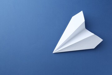 One handmade paper plane on blue background, top view. Space for text