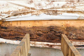 Removed Deck Ledger Board Reveals Dry Rotten Rim Joist Board with Extensive Damage on House