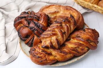 Different sweet pastries on white tiled table, closeup
