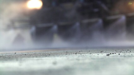 A Misty Urban Street with Motion Blur Creating a Dynamic Effect and Water Spraying Around. Stock...