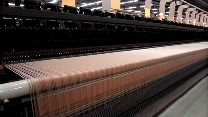 Rows of automated looms operating in harmony with threads moving swiftly through the air showcasing their ability to weave large rolls of fabric efficiently.