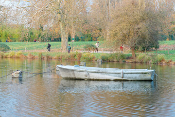 Exploring Bois de Vincennes at dusk with serene waters and leisurely walkers in Paris