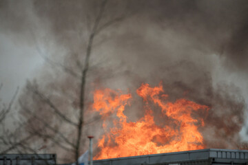 Large fire with heavy smoke billowing from a building.  Flames engulf the structure.