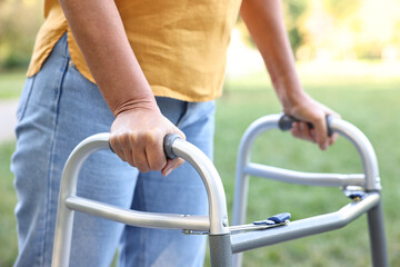Obraz premium Senior woman with walking frame in park, closeup