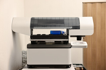 Modern printer and empty bottle in room
