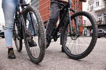 Fototapeta premium Couple with bicycles spending time together outdoors, closeup