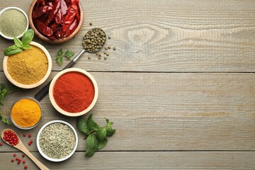 Different aromatic spices on wooden table, flat lay. Space for text