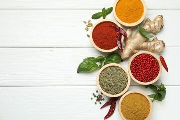 Different aromatic spices on white wooden table, flat lay. Space for text
