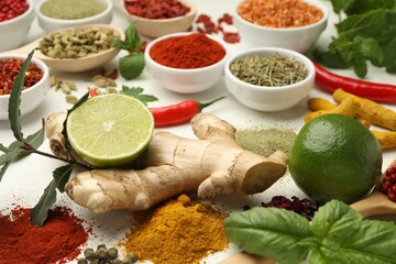 Different aromatic spices, lime and herbs on white background, closeup