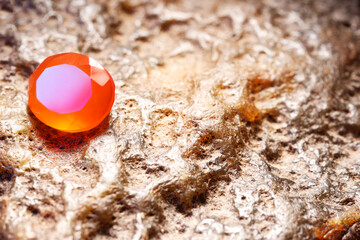 Beautiful shiny orange gemstone on stone, space for text