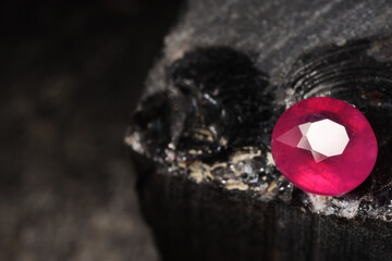 Obraz premium Beautiful shiny pink gemstone on stone, space for text