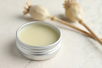 Natural solid perfume in container and plant on white table, closeup. Space for text