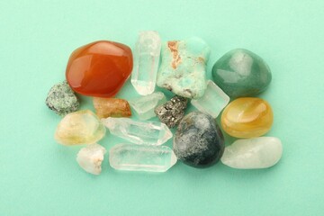 Beautiful natural gemstones on turquoise background, flat lay