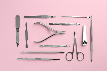 Set of pedicure tools on pink background, flat lay