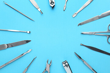 Set of pedicure tools on light blue background, flat lay. Space for text