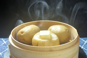 湯気が立ち昇る蒸籠でじゃがバター調理する