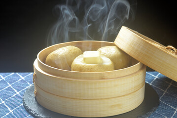 湯気が立ち昇る蒸籠でじゃがバター調理する