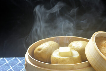 湯気が立ち昇る蒸籠でじゃがバター調理する