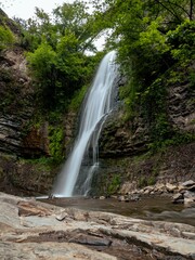 Obraz premium A peaceful waterfall in Tbilisi's botanical garden surrounded by lush greenery