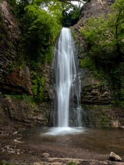 A peaceful waterfall in Tbilisi's botanical garden surrounded by lush greenery