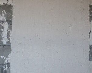Uneven wall with gypsum plaster. Gray rough wall with plastered surface. Finishing walls in an apartment using plaster on leveling guide profiles
